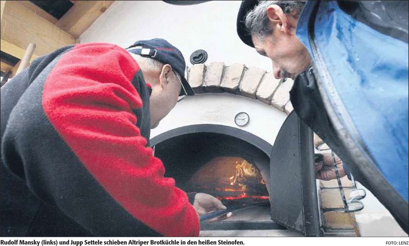 Rudolf Mansky (links) und Jupp Settele schieben Altriper Brotküchle in den heißen Steinofen. | Quelle: DIE RHEINPFALZ – Ludwigshafener Rundschau – 13. November 2012 | Text: Maja Lüken| Foto: Lenz | Mit freundlicher Genehmigung der RHEINPFALZ Verlag und Druckerei GmbH & Co. KG in Ludwigshafen.
