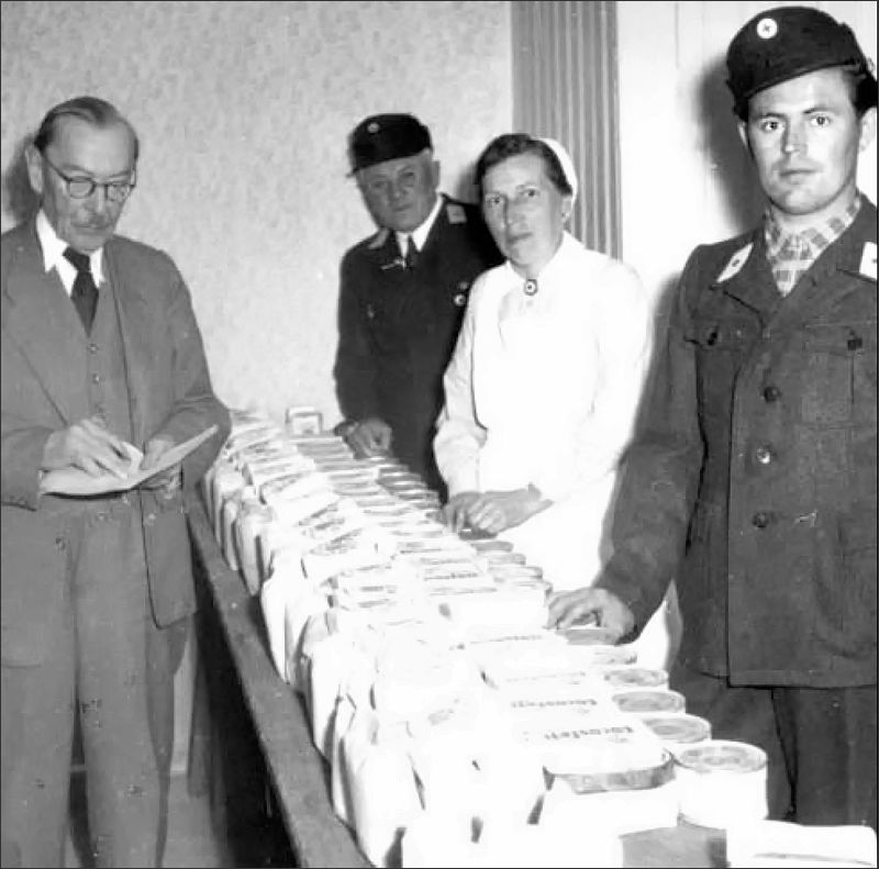 Altriper Lebensmittelverteilerstelle im alten Spritzenhaus: Links macht sich Dorfarzt Dr. Theodor Horn Notizen, am rechten Bildrand steht Georg Regenauer